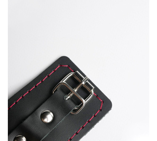 Черные кожаные наручники с красной строчкой